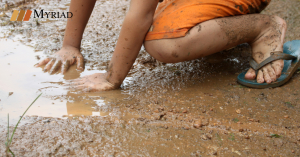 niño jugando con agua sucia