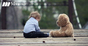 Niño triste con oso de peluche