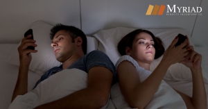 Pareja utilizando dispositivos móviles en la cama