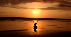 persona meditando en la playa